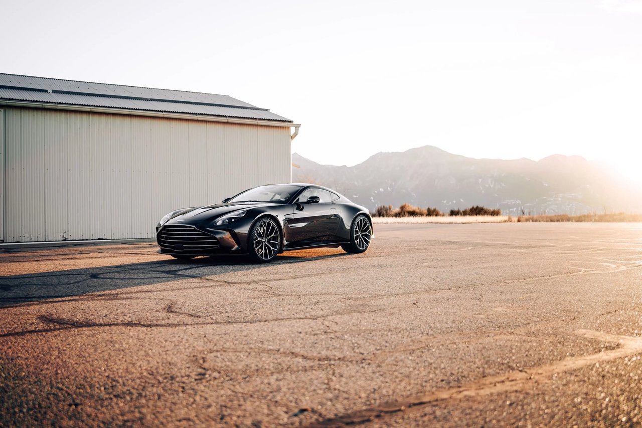 Tattered's Black Aston Martin Vantage parked at an airfield at sunset, featured on Visor